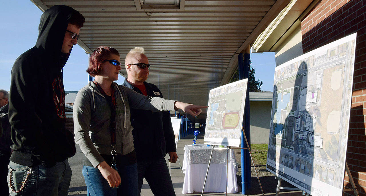 Kaleta and Erik Kingman-Gatz with their son Evan, a seventh-grader at Olympic Middle School, look at what the new school will look at during the recent groundbreaking. RACHEL CIAMPI, Auburn Reporter