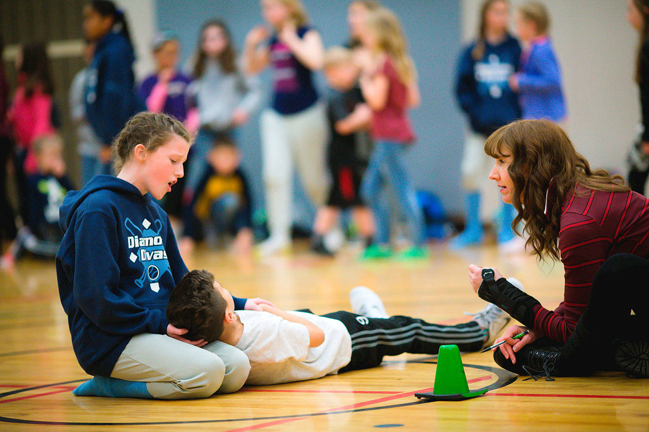 Belle, played by Maddie McCarthy, holds the fallen Beast, Enrique Strong, in her lap as co-director 
Caroline Heilborn looks on during a rehearsal of “Beauty and the Beast” at Lakeland Hills Elementary School. COURTESY, Cassandra Hamilton Photography