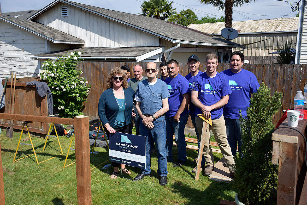 Mayor Nancy Backus and volunteers workers pause to pose during construction of a ramp for the Snider family last Saturday. COURTESY PHOTO