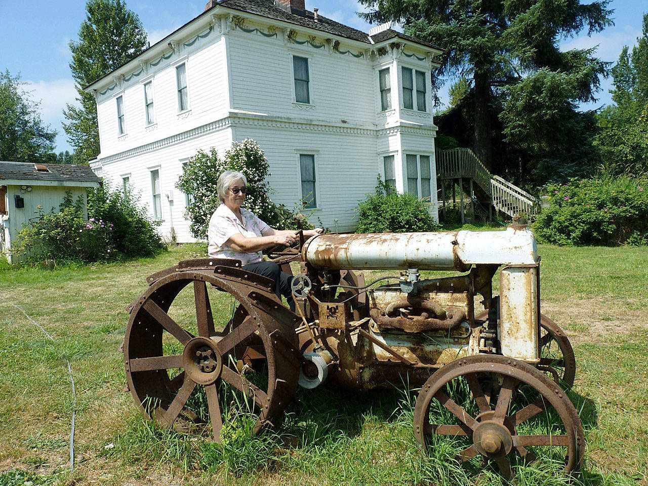 Julie Acosta, a Neely Mansion Association board member, visits Neely Mansion and one of its vintage tractors. She is the daughter of Pete Acosta, an immigrant from the Philippines, who lived and farmed at Neely Mansion for more than 40 years. COURTESY PHOTO, Neely Mansion Association