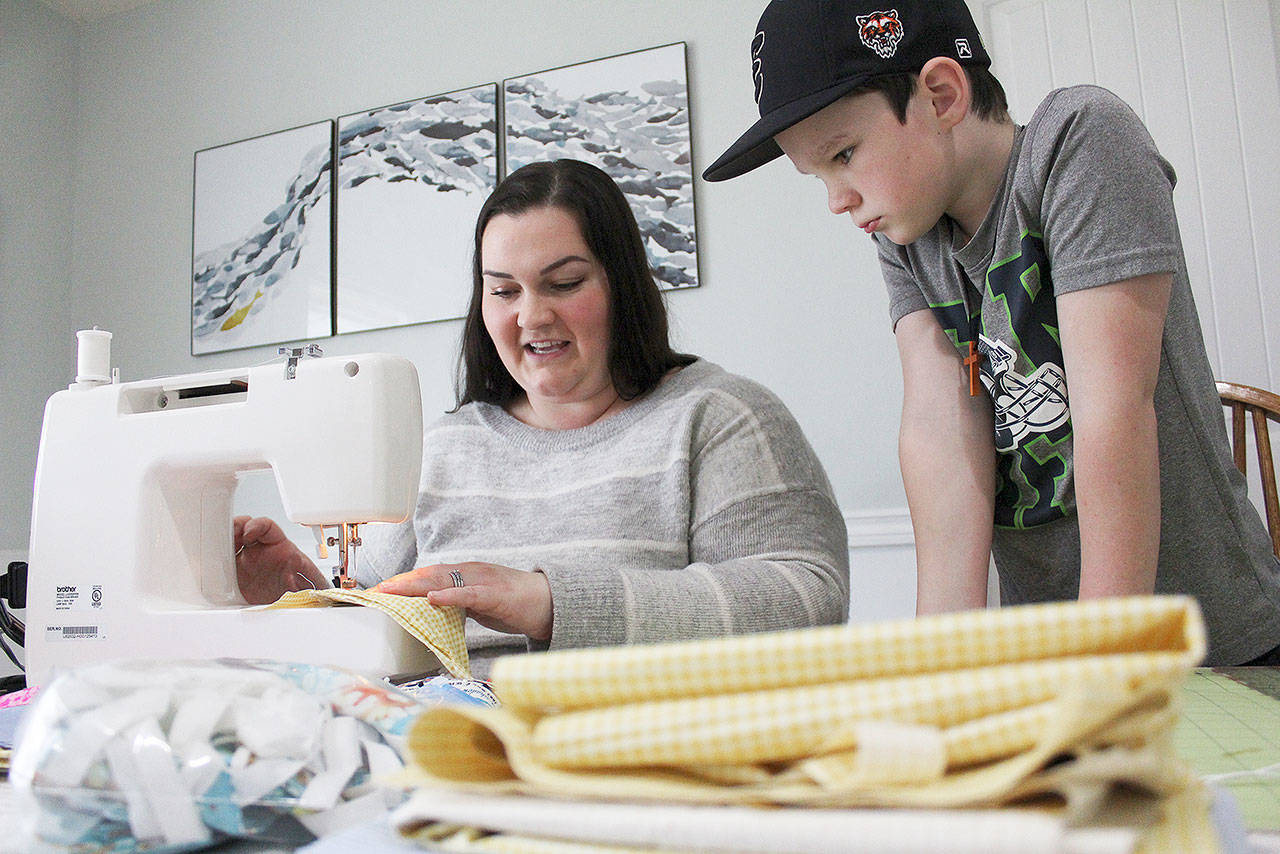 Angie Adam has been using materials given to her from her great grandmother to sew masks for healthcare workers. Photo by Ray Miller-Still