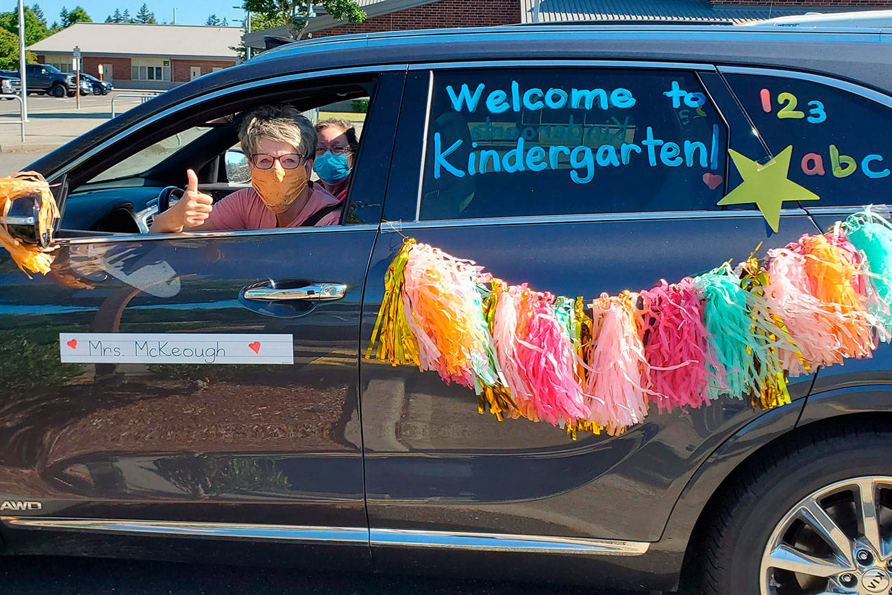 A Lakeland Hills Elementary teacher riding in the district’s car and bus parade last week signals her eagerness to welcome students to school on opening day Sept. 9. Courtesy photo