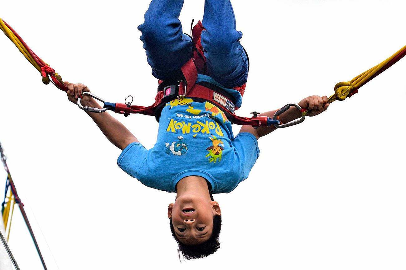 Christian Cordova does flips on the bungie trampoline at the 2019 Kids Day. File photo