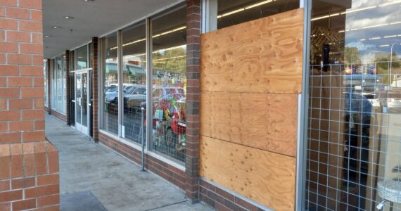 Carly Willis, owner of Antique Marketplace on Howard Road, has left the plywood up on her burglary-shattered window because she said it’s not worth fixing, given the numerous break-ins her business has suffered recently. Photo by Robert Whale, Auburn Reporter.