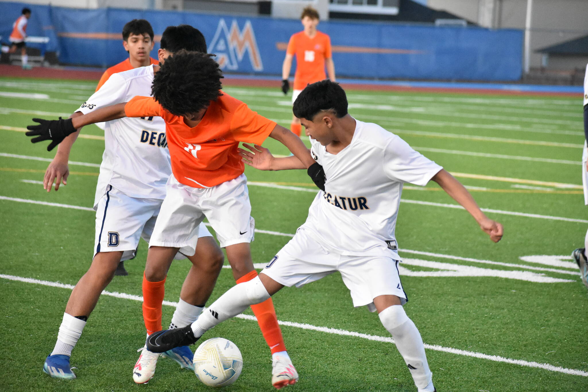 Benjamin Yitbarek battles two Decatur players for the ball. Ben Ray / The Reporter