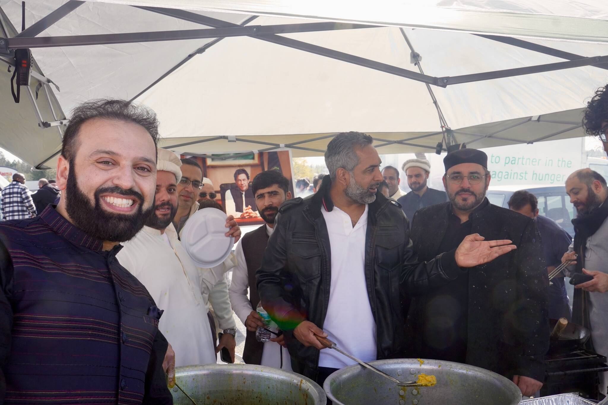 Men serving halal food on Eid Mubarak 2024. Photo By Joshua Solorzano/Sound Publishing