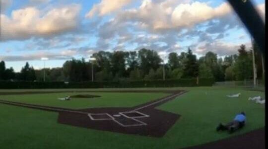 A video shows players on a baseball field in Auburn taking cover amid the sound of gunshots May 19. (Screenshot)
