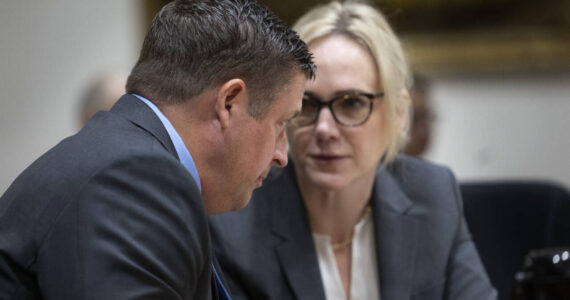 Jeffrey Nelson speaks with his counsel, Emma Scanlan. (Ken Lambert / The Seattle Times)