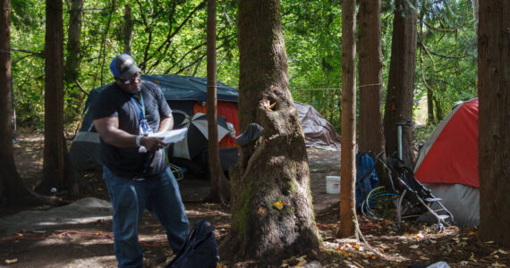 Homelessness Outreach Program Coordinator Kent Hay delivering mail to a resident of a homeless camp in Auburn. Sound Publishing file photo