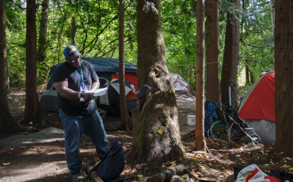 Homelessness Outreach Program Coordinator Kent Hay delivering mail to a resident of a homeless camp in Auburn. Sound Publishing file photo