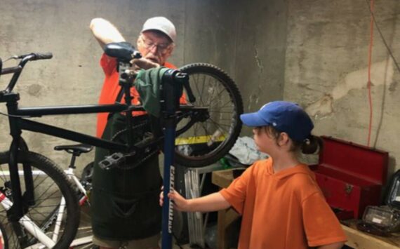 Volunteer Greg Neiman and a young helper work on a bike donated to Bikes for Kids. Courtesy photo