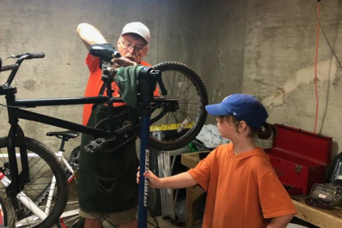 Volunteer Greg Neiman and a young helper work on a bike donated to Bikes for Kids. Courtesy photo