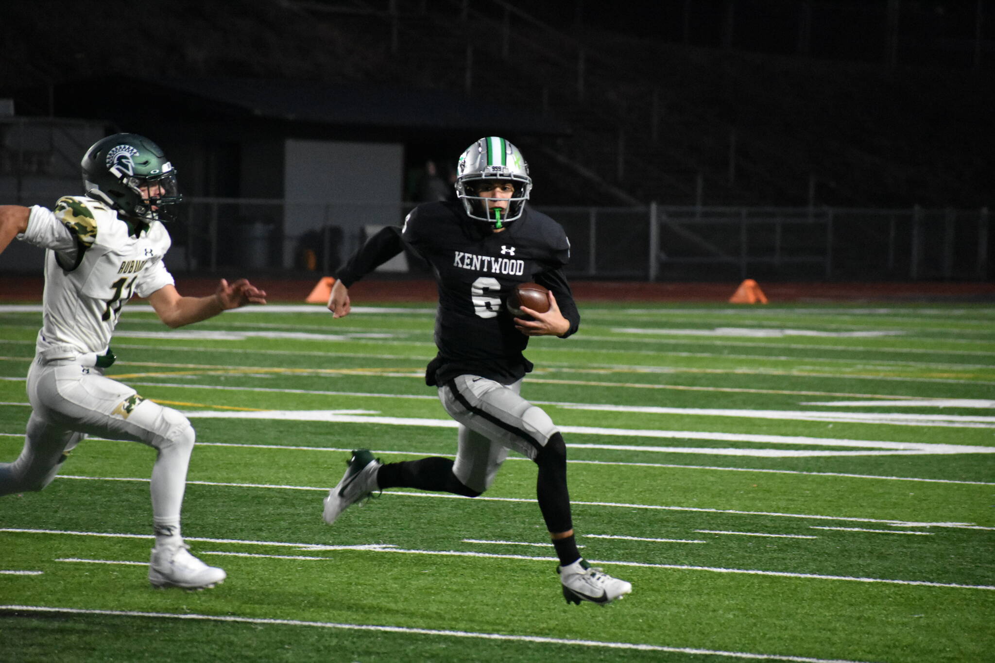 Kentwood quarterback Brandon Tagle outruns an Auburn defender for a first down in the second half. Ben Ray / The Reporter