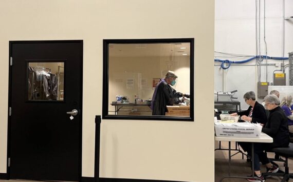 Election workers open mail in a new secure room at Thurston County’s elections office. The county invested in a separate room to open mail after it was sent an envelope containing fentanyl last year. (Laurel Demkovich/Washington State Standard)