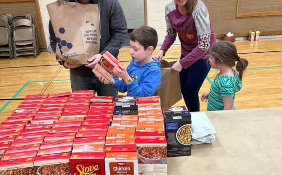 Seth and Katie Price, along with their children Isaac and Brielle, assemble meals-in-a-bag at the Auburn congregation of The Church of Jesus Christ of Latter-day Saints for families in need, as part of a food drive benefiting Vine Maple Place. Courtesy photo.