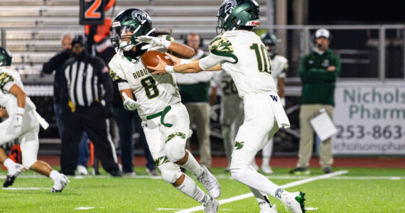 RJ Conlan #8 of the Auburn Trojans takes a handoff during a football game against the Sumner Spartans at Sunset Chev Stadium on Nov. in Sumner. Photos by Henry Rodenburg