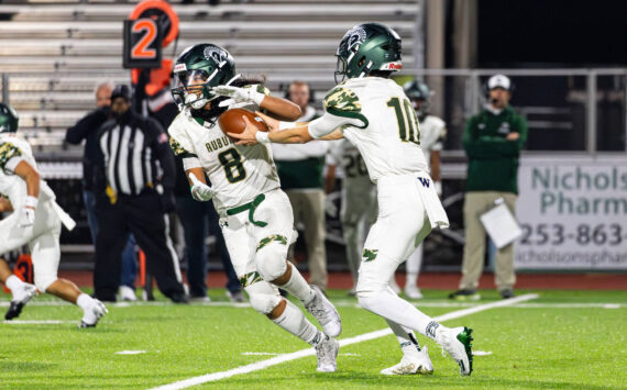 RJ Conlan #8 of the Auburn Trojans takes a handoff during a football game against the Sumner Spartans at Sunset Chev Stadium on Nov. in Sumner. Photos by Henry Rodenburg