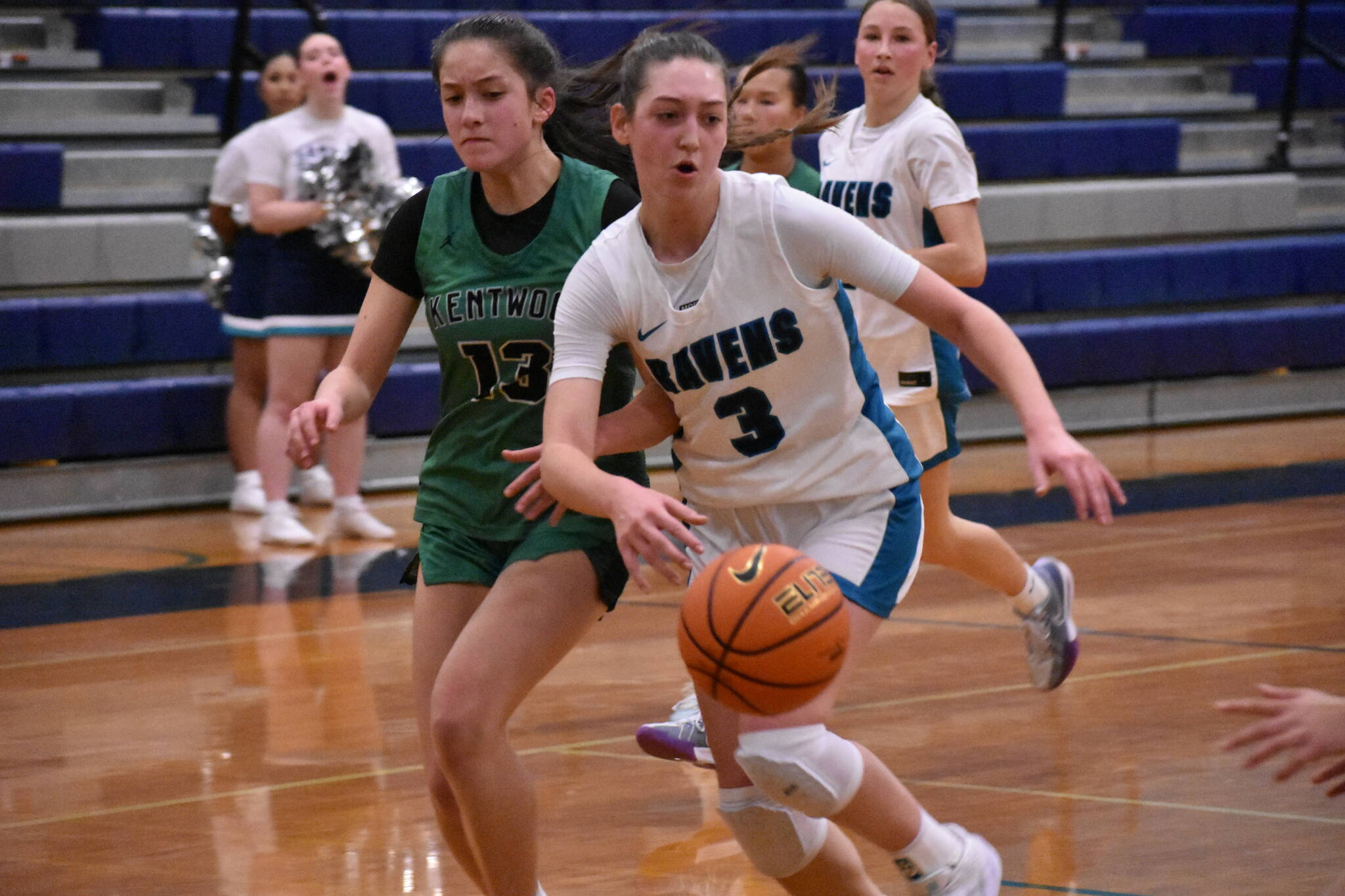 Cora Lowe fights off a Kentwood defender as she drives to the basket. Ben Ray / The Reporter