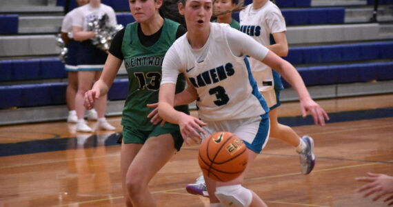 Cora Lowe fights off a Kentwood defender as she drives to the basket. Ben Ray / The Reporter