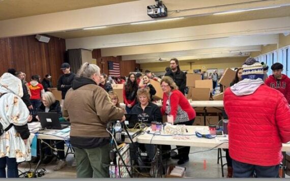 Auburn Food Bank Director Debbie Christian and Auburn Mayor Nancy Backus at the Dec. 23 annual Christmas distribution of food boxes for local people and families in need in the Fellowship Hall at Holy Family Catholic Church. Courtesy photo, City of Auburn.