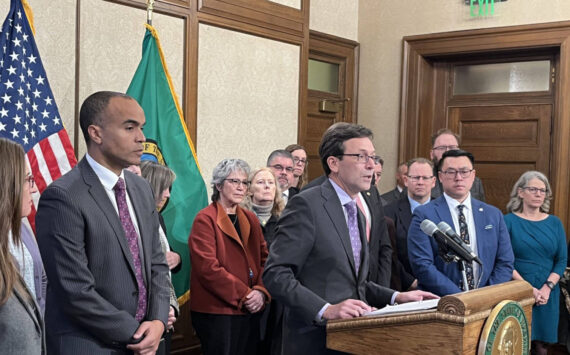 Gov. Bob Ferguson, surrounded by other state elected leaders, speaks at a Feb. 13 press conference in Olympia. (Photo by Bill Lucia/Washington State Standard)